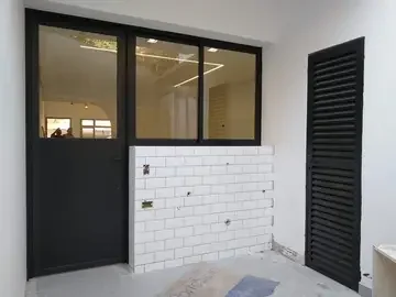 Porta de giro preta instalada em área de serviço