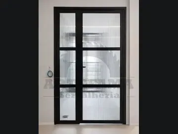 Porta de giro preta de alumínio e vidro canelado executada pela Artefama