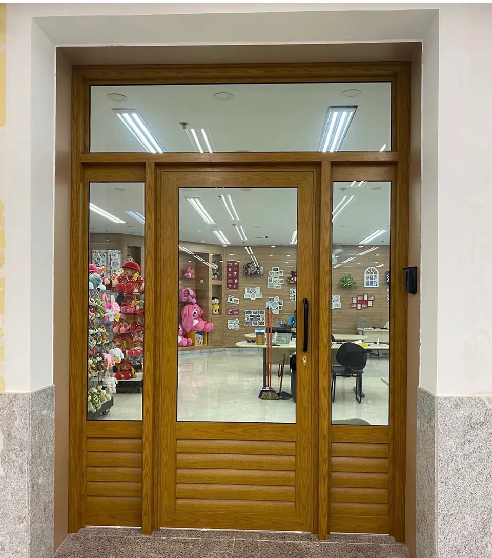 Porta com acabamento amadeirado, vidro e ventilação inferior