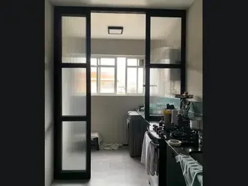 Porta suspensa preta com vidro translúcido entre ambientes