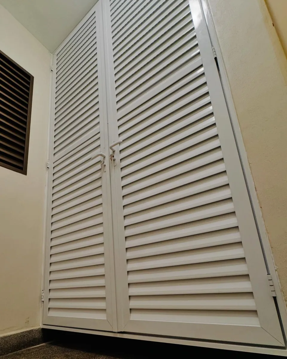 Fechamento técnico de alumínio com três portas venezianas